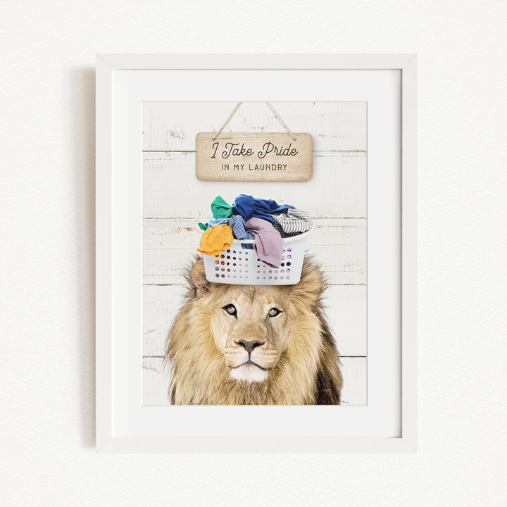 A framed image of a lion with a basket of laundry on its head, accompanied by a wooden sign that reads "I Take Pride in My Laundry".