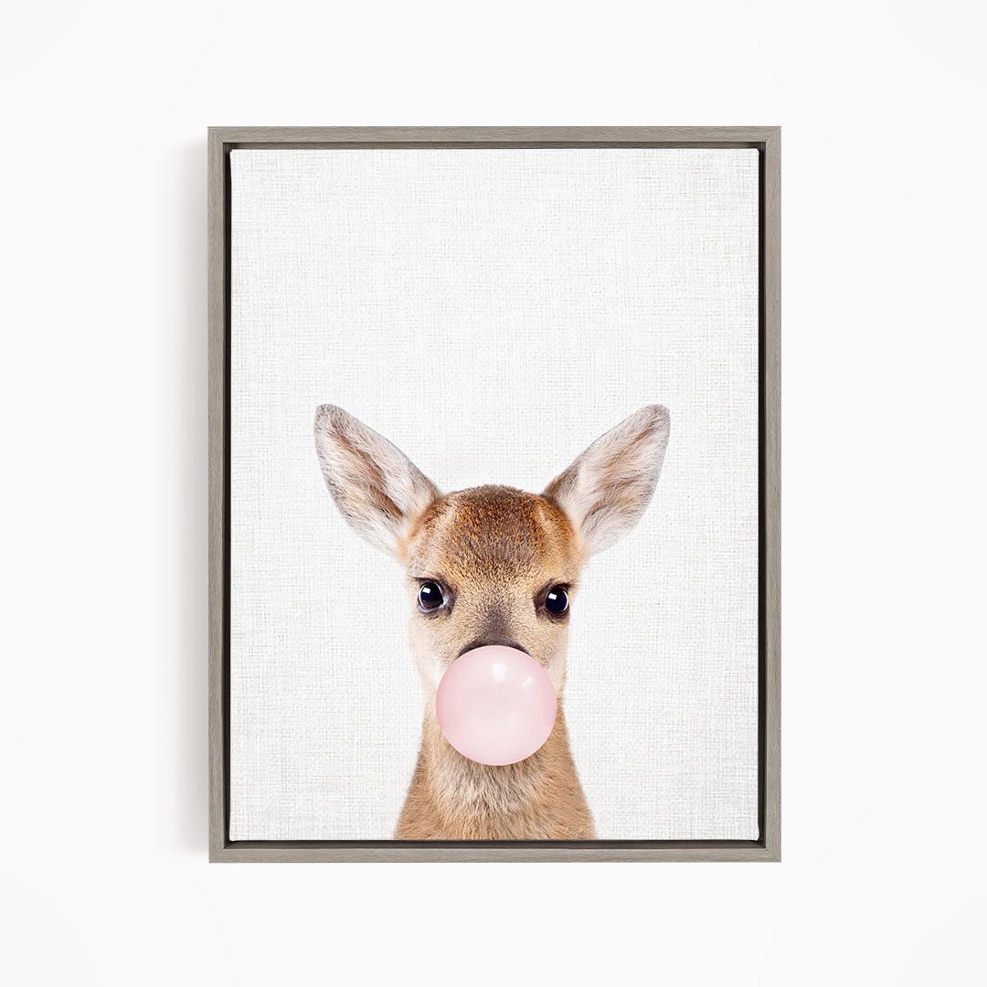 A deer with large ears blowing a pink bubblegum bubble.