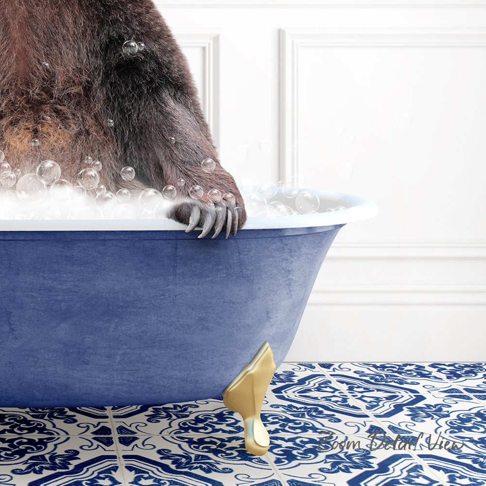 A close-up of a bear's paw resting on the edge of a blue bathtub filled with bubbles, with a patterned tile floor in the background.