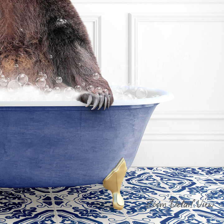 A close-up of a bear's paw resting on the edge of a blue bathtub filled with bubbles, with a patterned tile floor in the background.