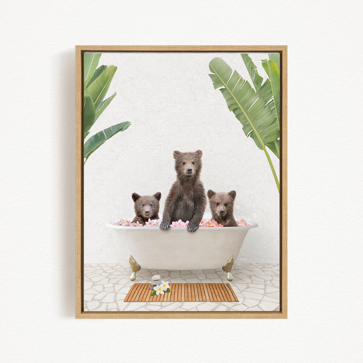 Three brown bears sitting in a white bathtub filled with pink and white bubbles, surrounded by green leaves.