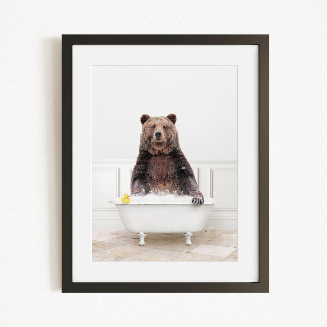 A brown bear sitting in a white bathtub, surrounded by a yellow rubber duck.