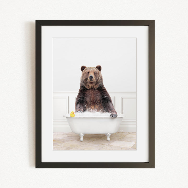 A brown bear sitting in a white bathtub, surrounded by a yellow rubber duck.