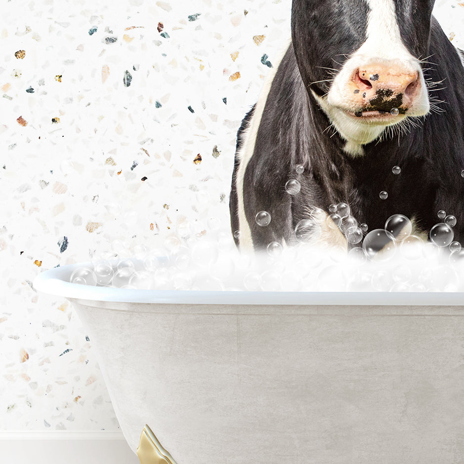 a black and white cow in a bathtub with bubbles