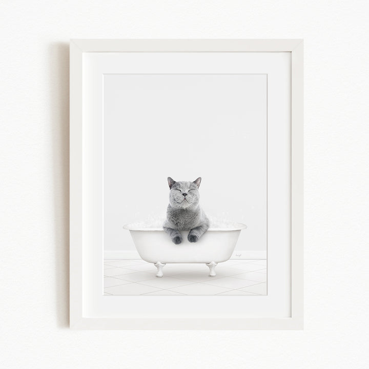 A gray cat sitting in a white bathtub, looking content and relaxed.