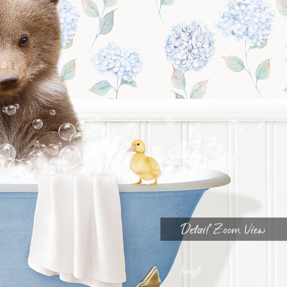 A brown bear is sitting in a blue bathtub filled with bubbles, with a yellow duck standing on the edge of the tub.