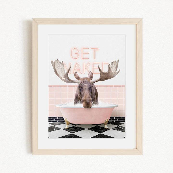 A framed image depicting a moose with large antlers sitting in a pink bathtub, with the text "GET NAKED" displayed above it.