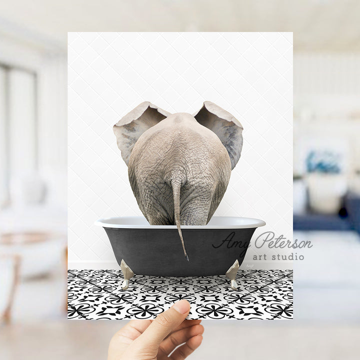 a person holding up a picture of an elephant in a bathtub