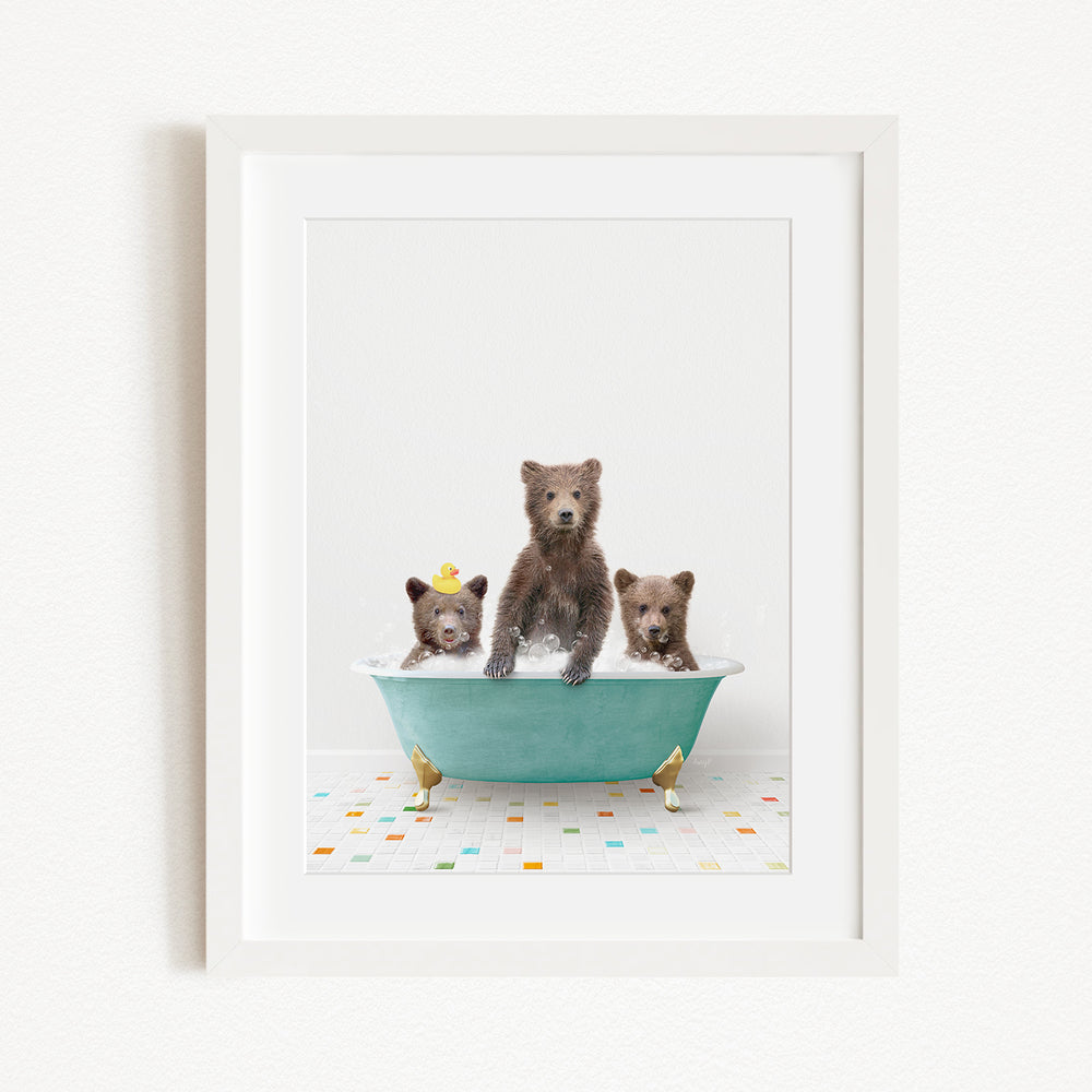 A framed image depicting three adorable brown bears sitting in a green bathtub filled with water, surrounded by colorful tiles on the floor.