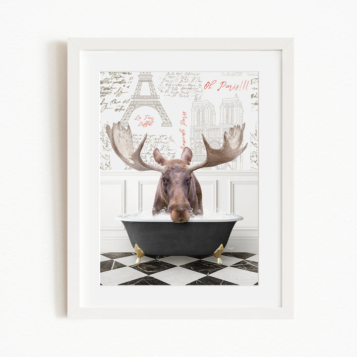 A moose is sitting in a bathtub, with a framed picture of the Eiffel Tower in the background.