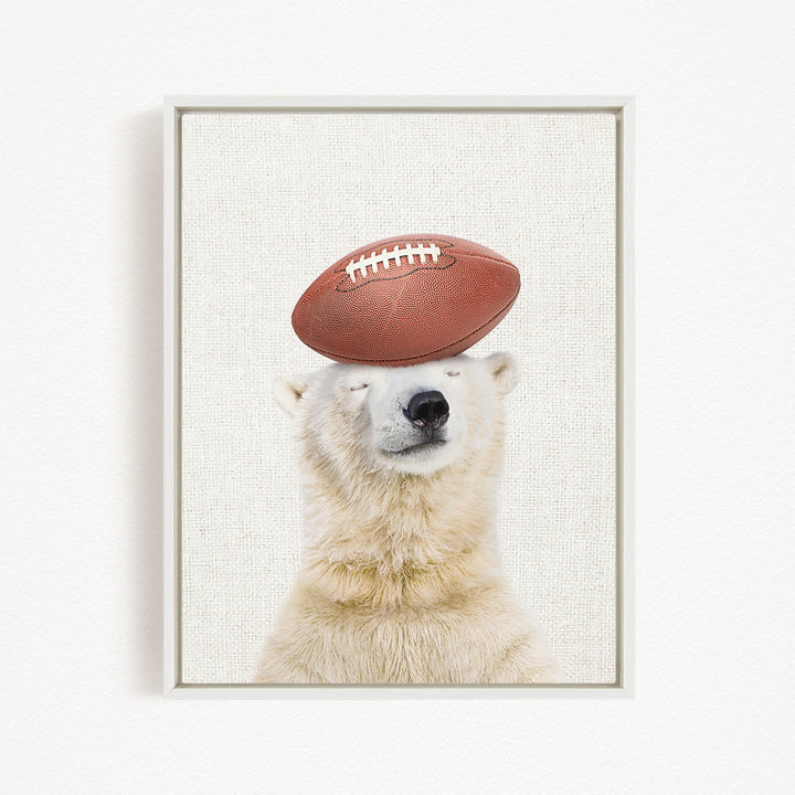 A polar bear balancing a football on its head.