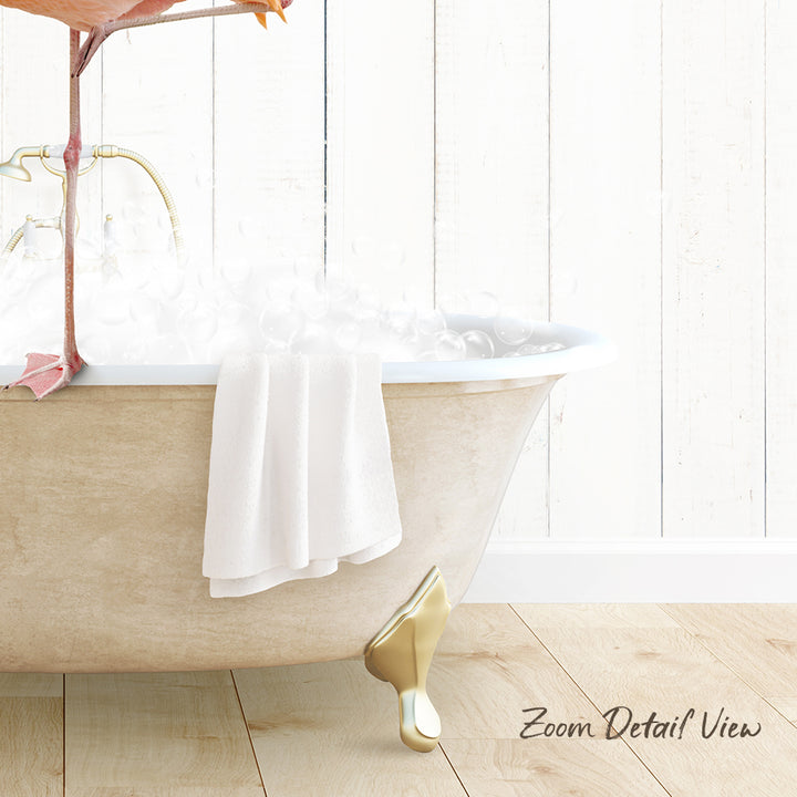 A white claw-foot bathtub filled with water and a white towel, with a pink flamingo perched on the edge of the tub.