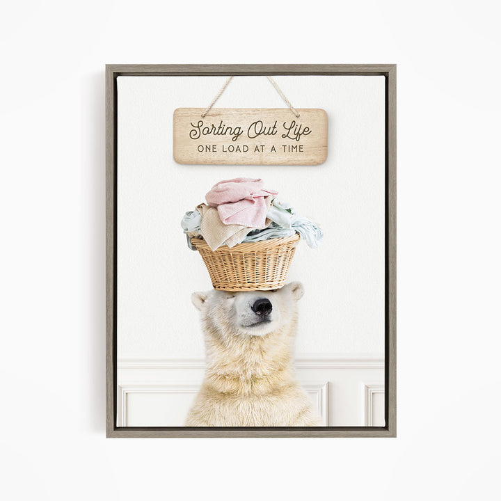 A polar bear balancing a basket of laundry on its head, with a sign above that reads "Sorting Out Life One Load at a Time".