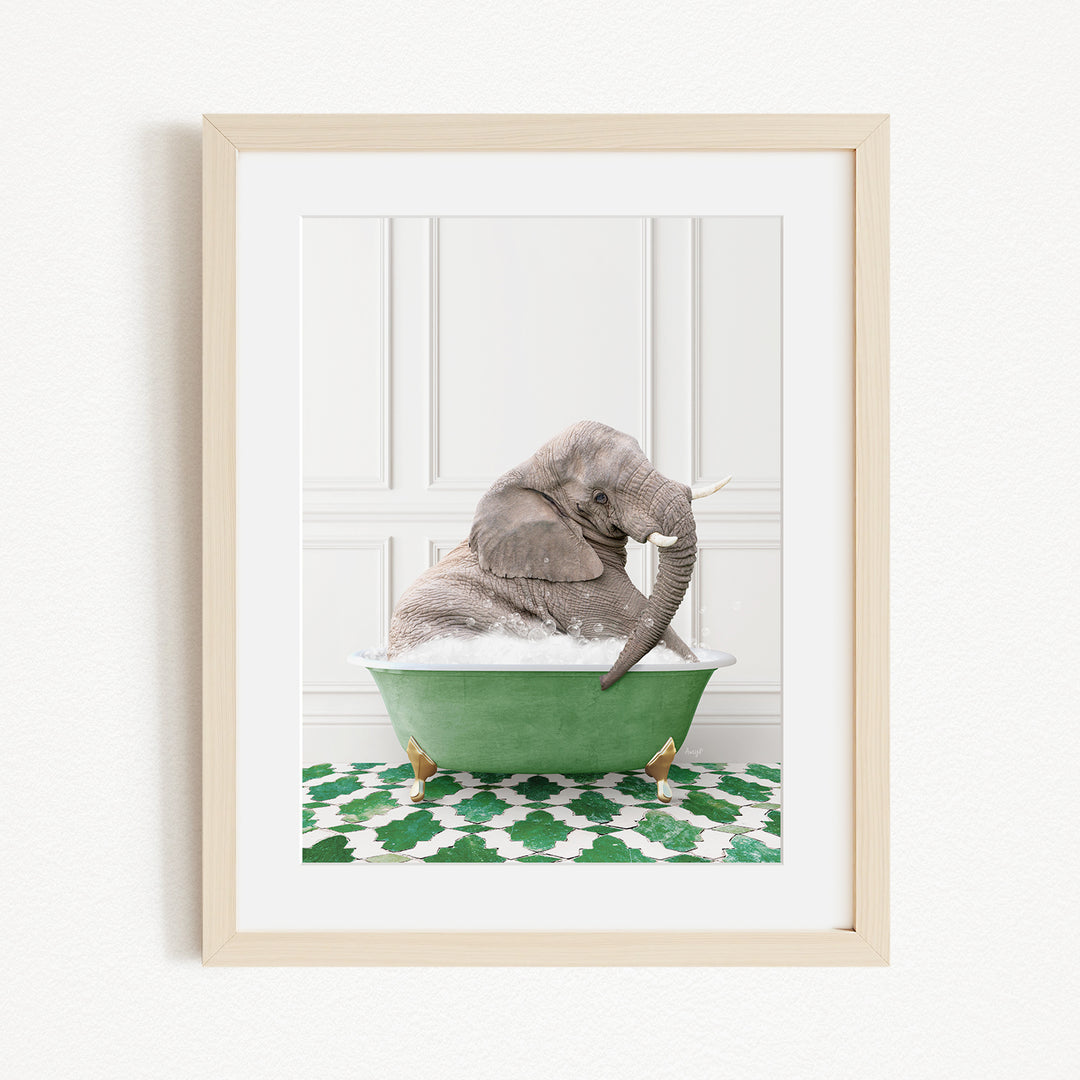 A gray elephant is sitting in a green bathtub filled with water, with its trunk raised in the air.