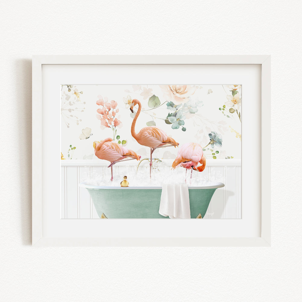 A framed image depicting three pink flamingos standing in a green bathtub filled with water, surrounded by flowers and greenery.