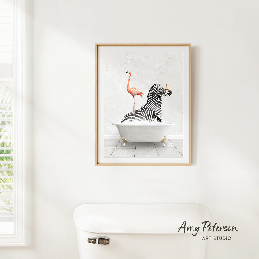 A framed print of a zebra sitting in a bathtub with a flamingo standing on its back, against a white wall.