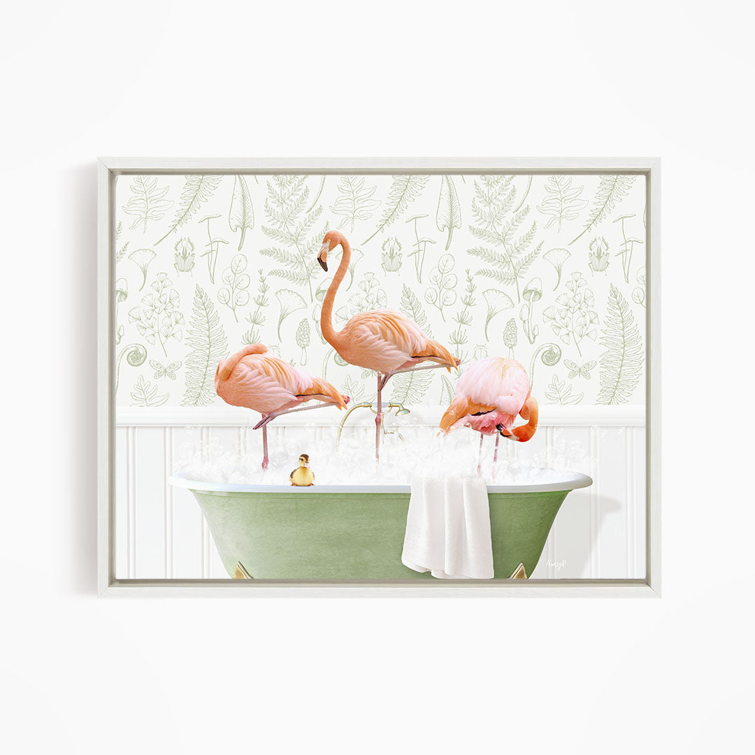 A framed image depicting three pink flamingos standing in a green bathtub filled with water, with a towel and a small rubber duck floating on the surface.