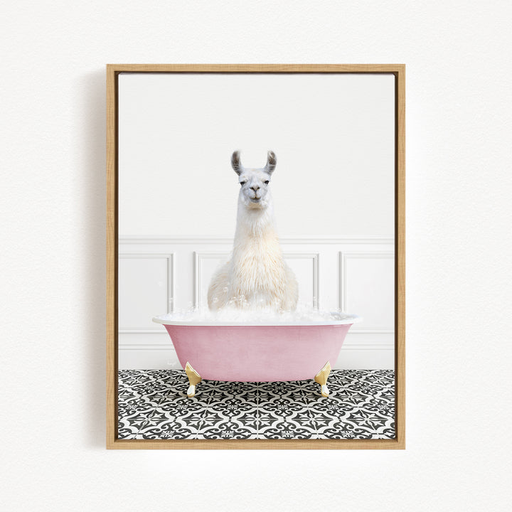 A white llama sitting in a pink bathtub filled with bubbles, with a black and white patterned floor in the background.