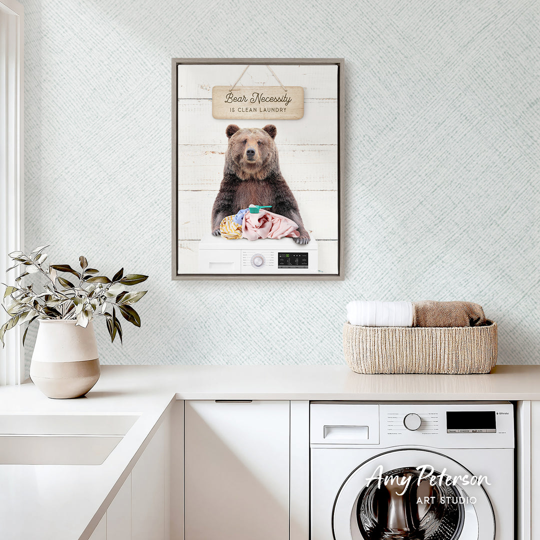 a framed picture of a bear sitting on a washer in a laundry room.