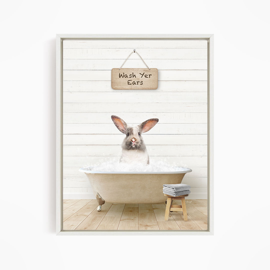 A white rabbit sitting in a bathtub filled with water, with a sign above that reads "Wash Your Ears".