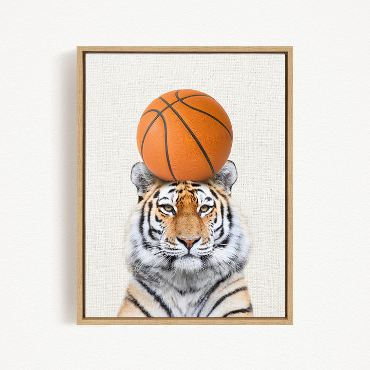 A tiger is sitting on a basketball, with the basketball positioned on its head.