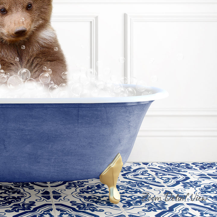 A brown bear is sitting in a blue bathtub filled with bubbles, with a patterned tile floor in the background.