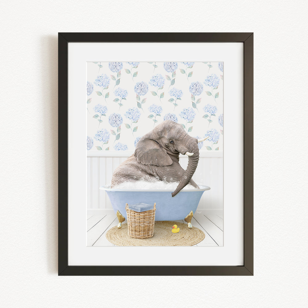 A gray elephant is sitting in a blue bathtub filled with water, surrounded by a wicker basket and yellow rubber ducks.