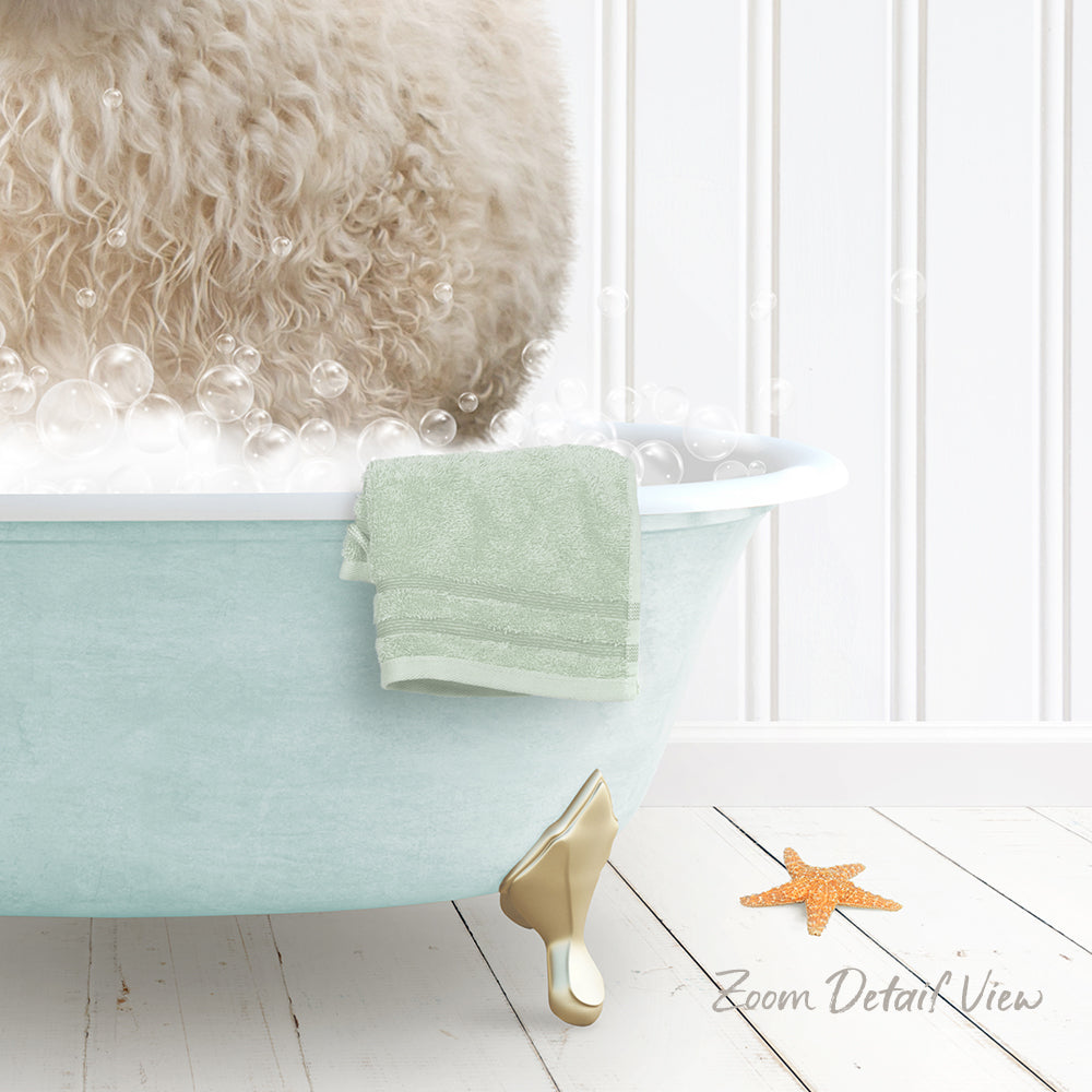 A fluffy white dog is sitting in a light blue bathtub filled with bubbles, with a green towel and a starfish nearby.