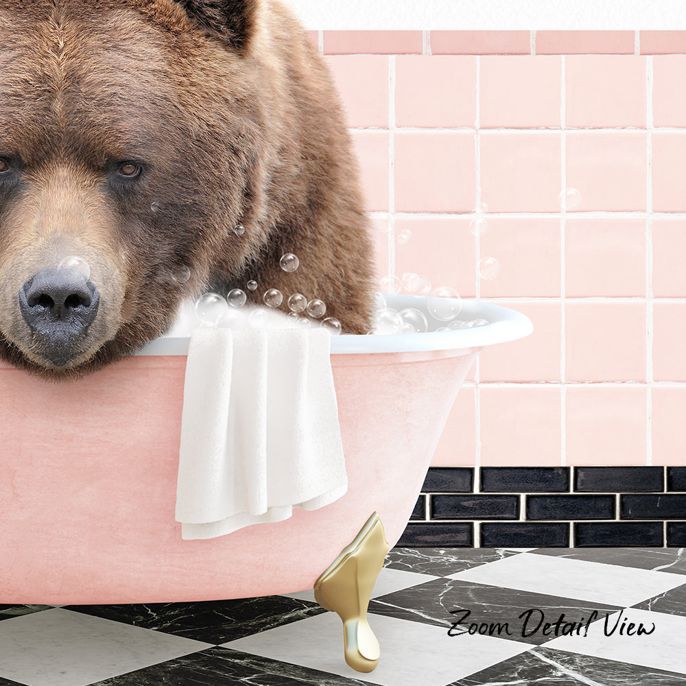A brown bear is sitting in a pink bathtub filled with bubbles, with a towel and gold bathtub leg visible.