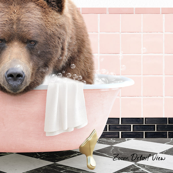 A brown bear is sitting in a pink bathtub filled with bubbles, with a towel and gold bathtub leg visible.