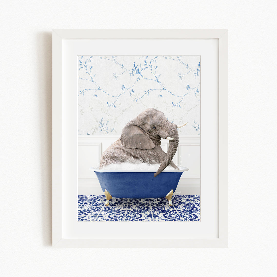 A gray elephant is sitting in a blue bathtub filled with bubbles, surrounded by a blue and white patterned rug.