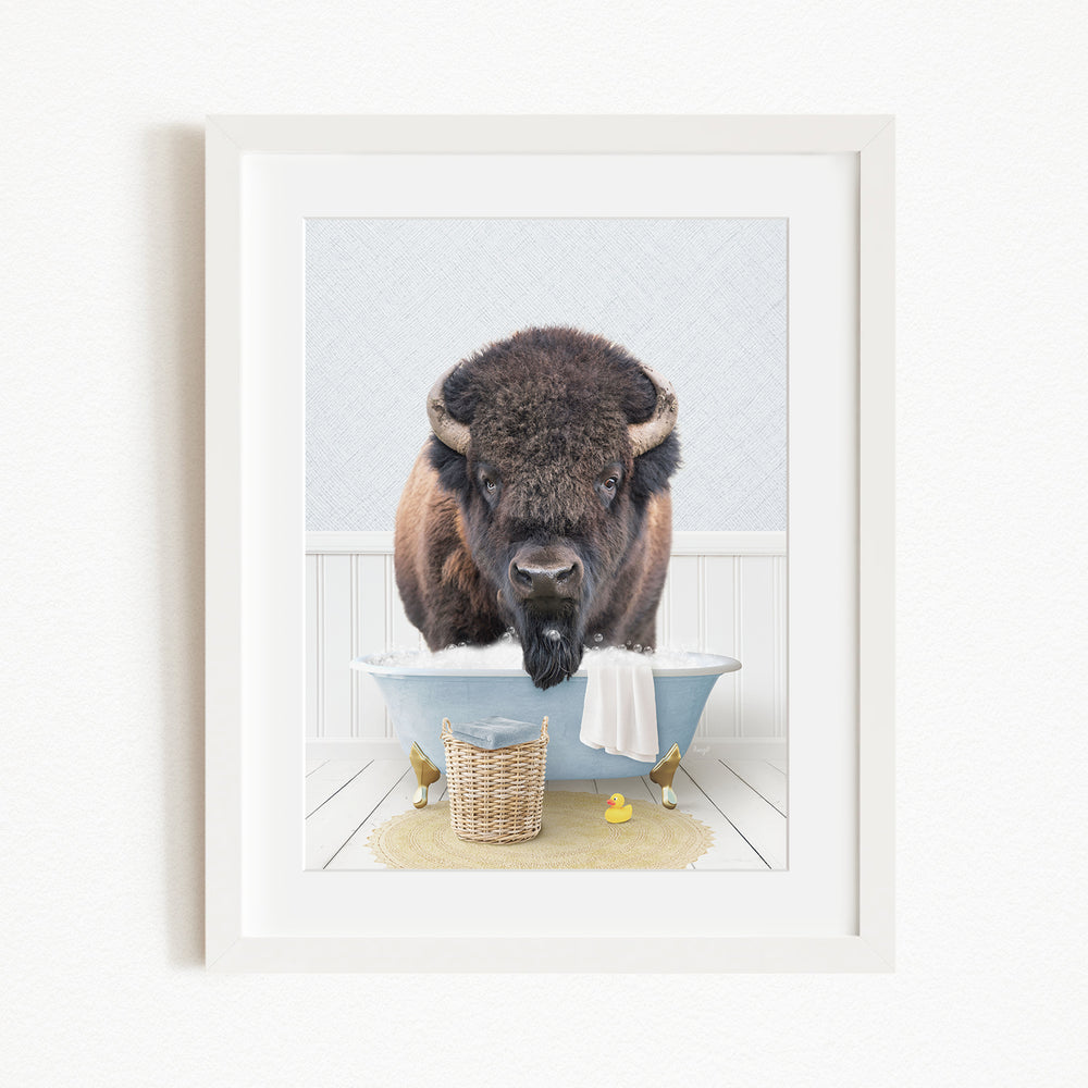 A buffalo standing in a bathtub filled with water, surrounded by rubber ducks and a basket.