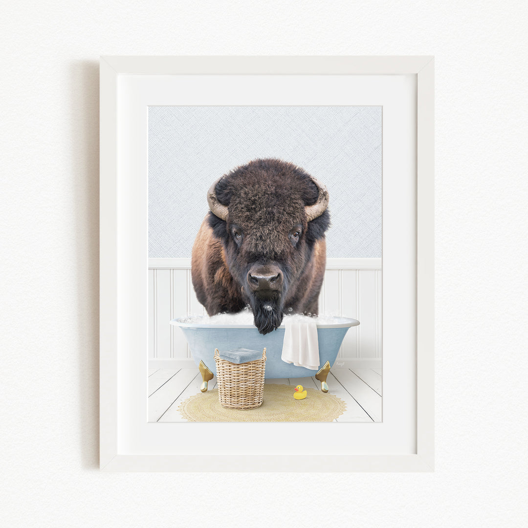 A buffalo standing in a bathtub filled with water, surrounded by rubber ducks and a basket.