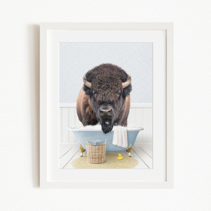A buffalo standing in a bathtub filled with water, surrounded by rubber ducks and a basket.