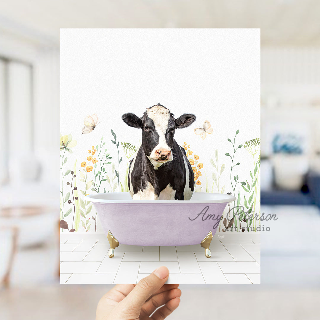 a hand holding up a card with a picture of a cow in a bathtub