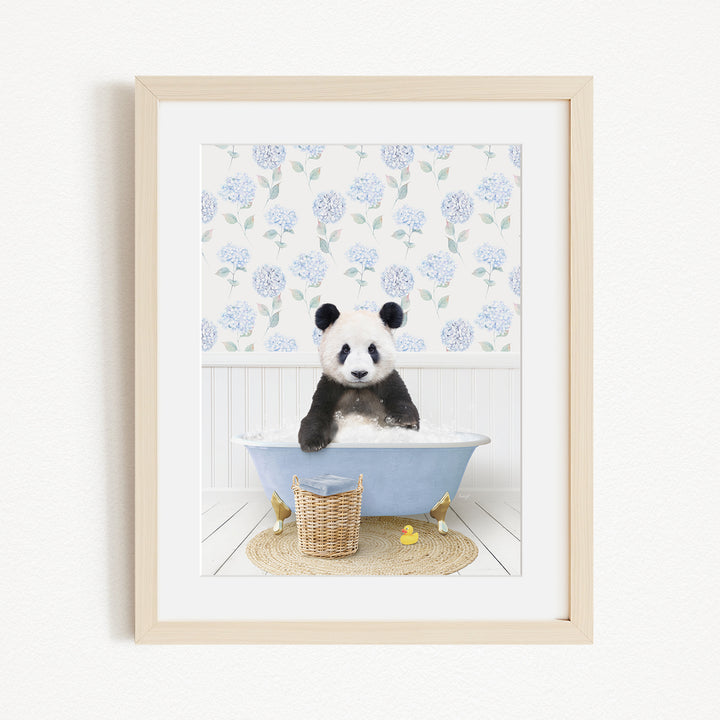 A panda bear sitting in a blue bathtub filled with bubbles, surrounded by a floral patterned wall and a basket of rubber ducks.
