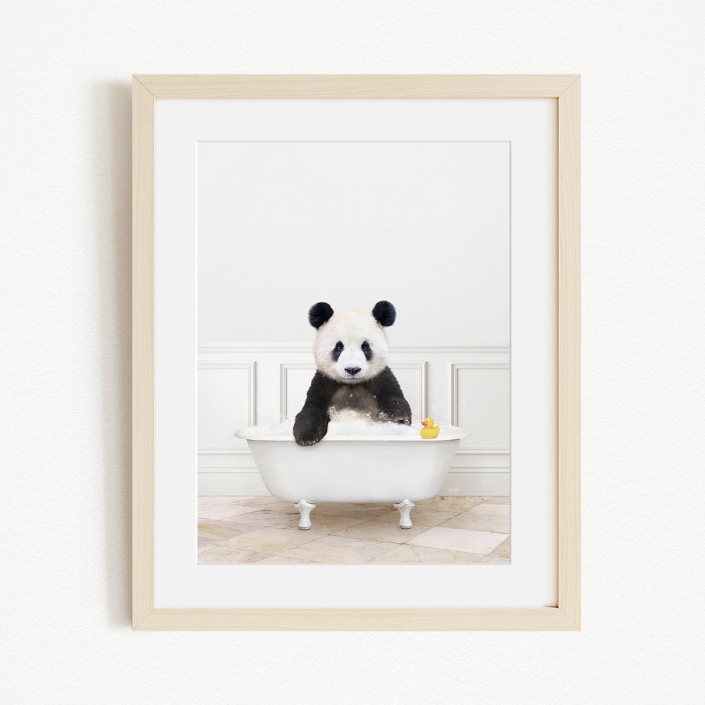 A panda bear sitting in a white bathtub, surrounded by a yellow rubber duck.