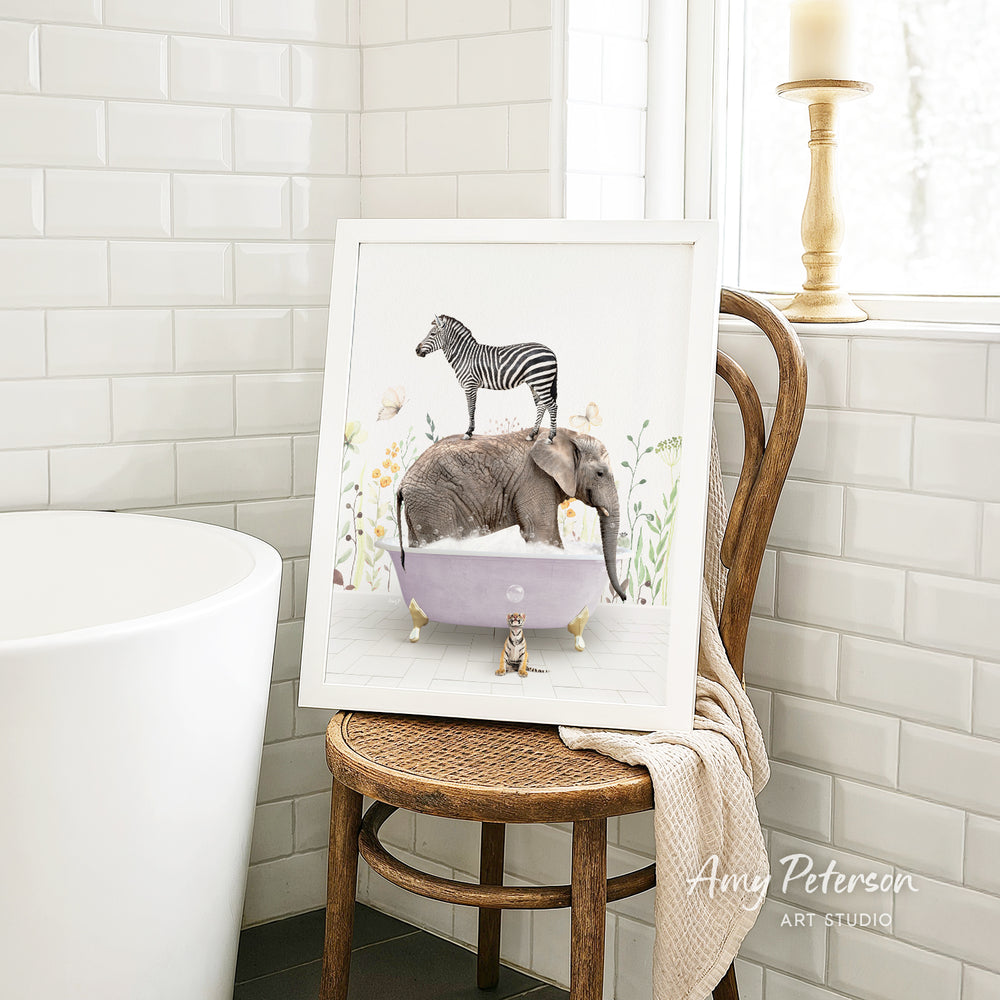 A framed illustration of a zebra standing on an elephant in a bathtub, surrounded by flowers, is displayed on a wooden chair in a bathroom setting.