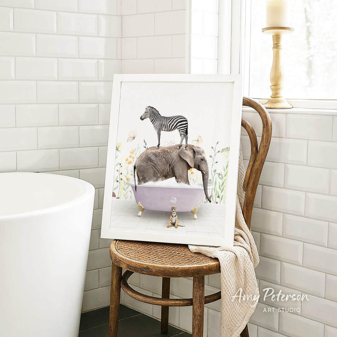 A framed illustration of a zebra standing on an elephant in a bathtub, surrounded by flowers, is displayed on a wooden chair in a bathroom setting.