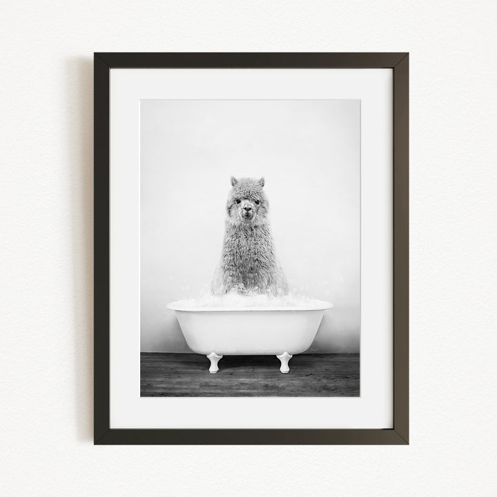 A black and white image of a fluffy, furry animal, possibly a dog or a cat, sitting in a white bathtub filled with water.