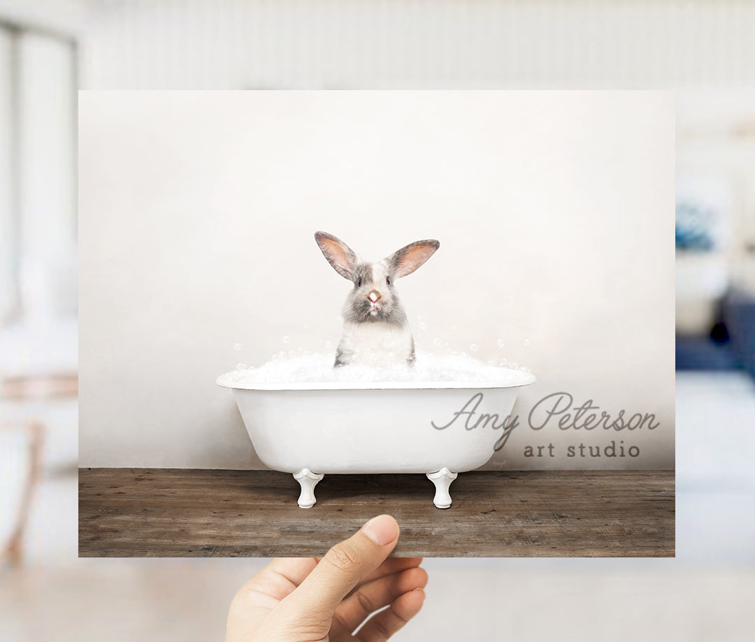 a person holding up a card with a picture of a rabbit in a bathtub