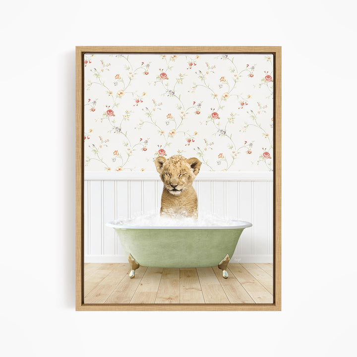 A young lion cub sitting in a green bathtub filled with water, with a floral wallpaper in the background.