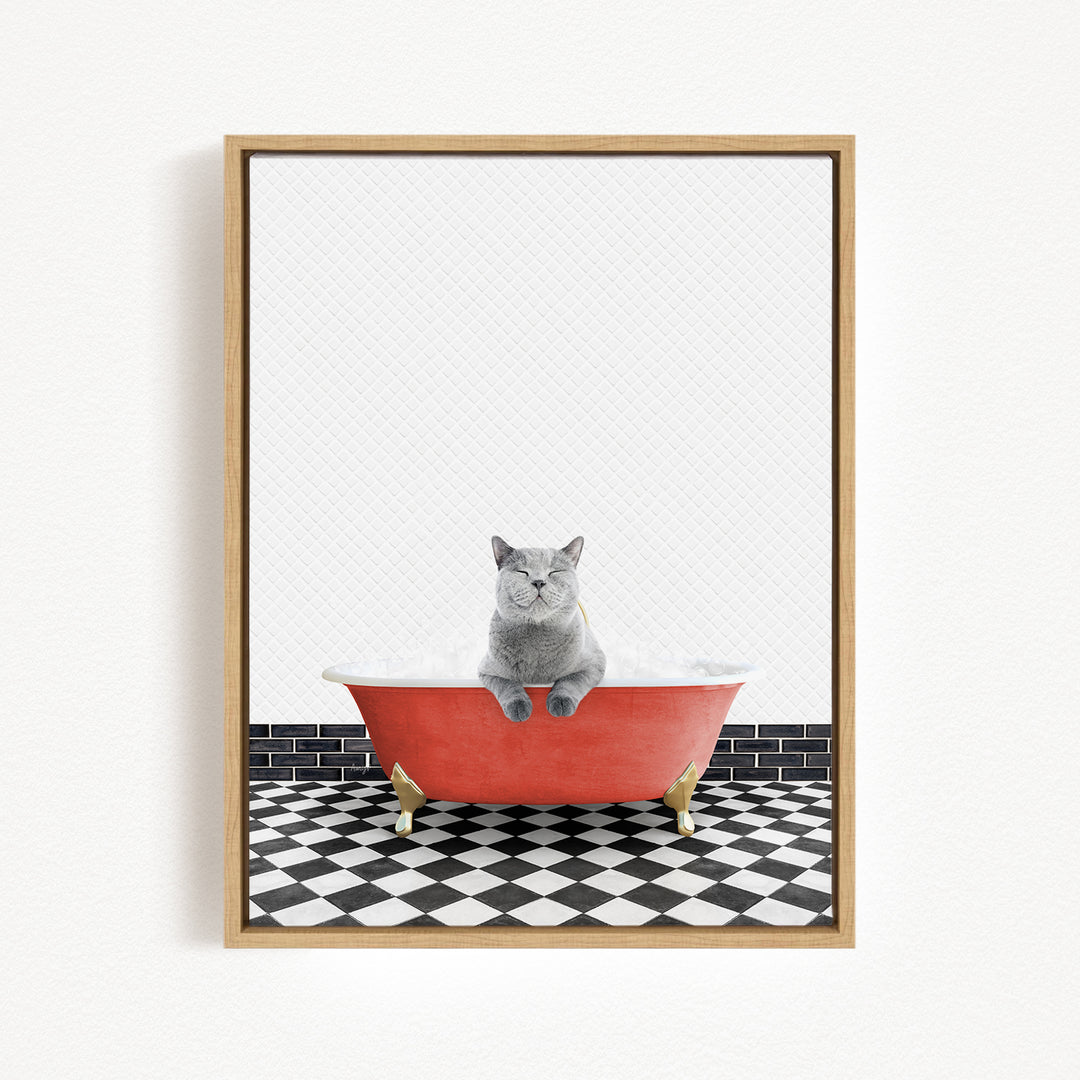 A gray cat sitting in a red bathtub on a black and white checkered floor.