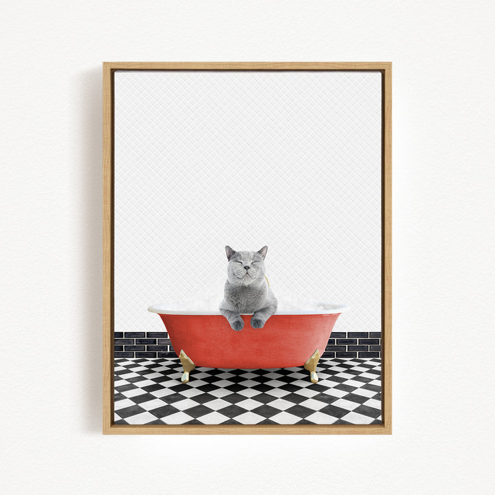 A gray cat sitting in a red bathtub on a black and white checkered floor.
