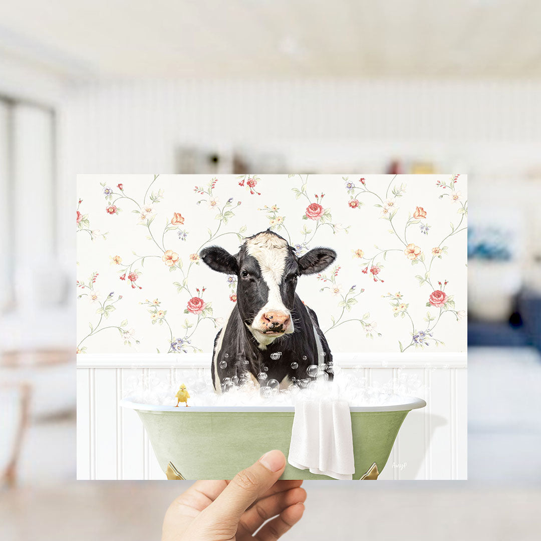 A black and white cow is sitting in a green bathtub filled with bubbles, with a yellow bird perched on the edge of the tub.
