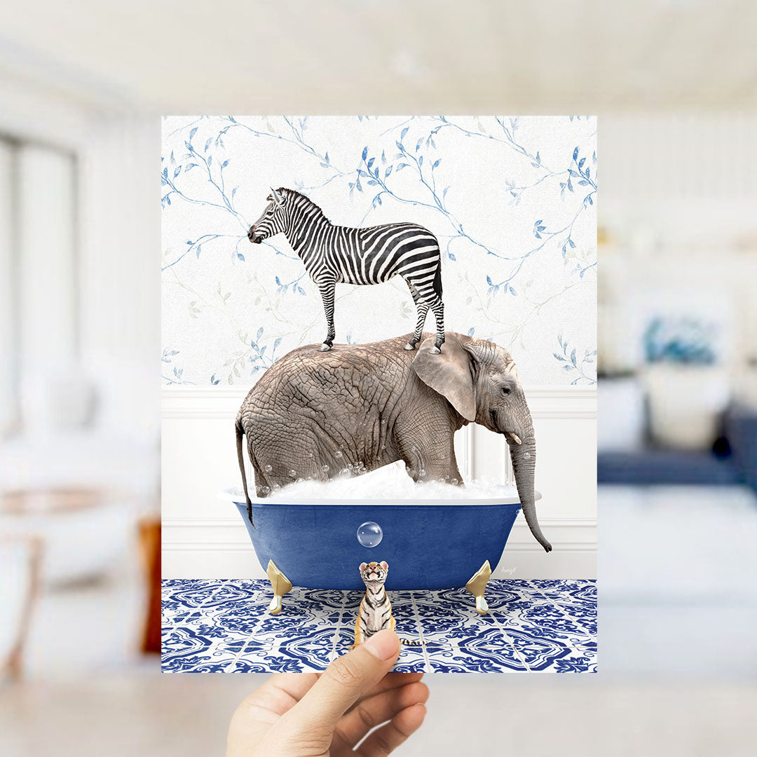 A hand holds up a collage of two images: a zebra standing on an elephant's back in a bathtub, and a small tiger figurine standing in front of the elephant.