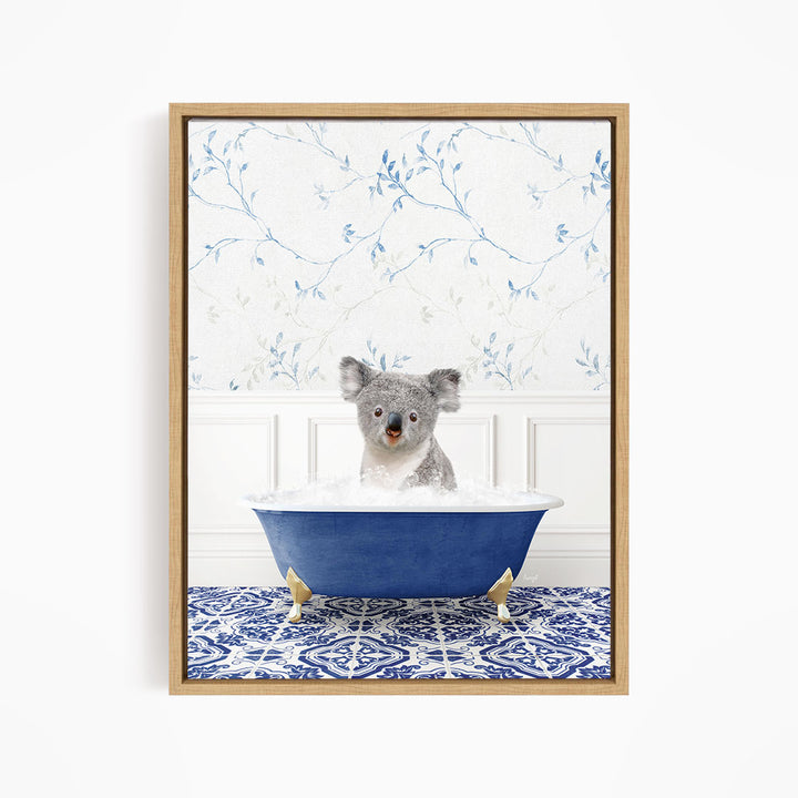 A koala bear sitting in a blue bathtub, surrounded by a blue and white patterned rug and a floral wallpaper background.