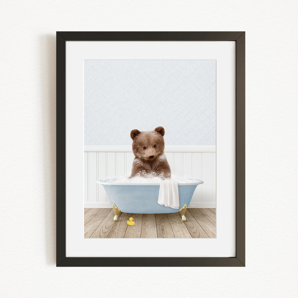 A cute brown bear sitting in a blue bathtub filled with water, surrounded by yellow rubber duckies.
