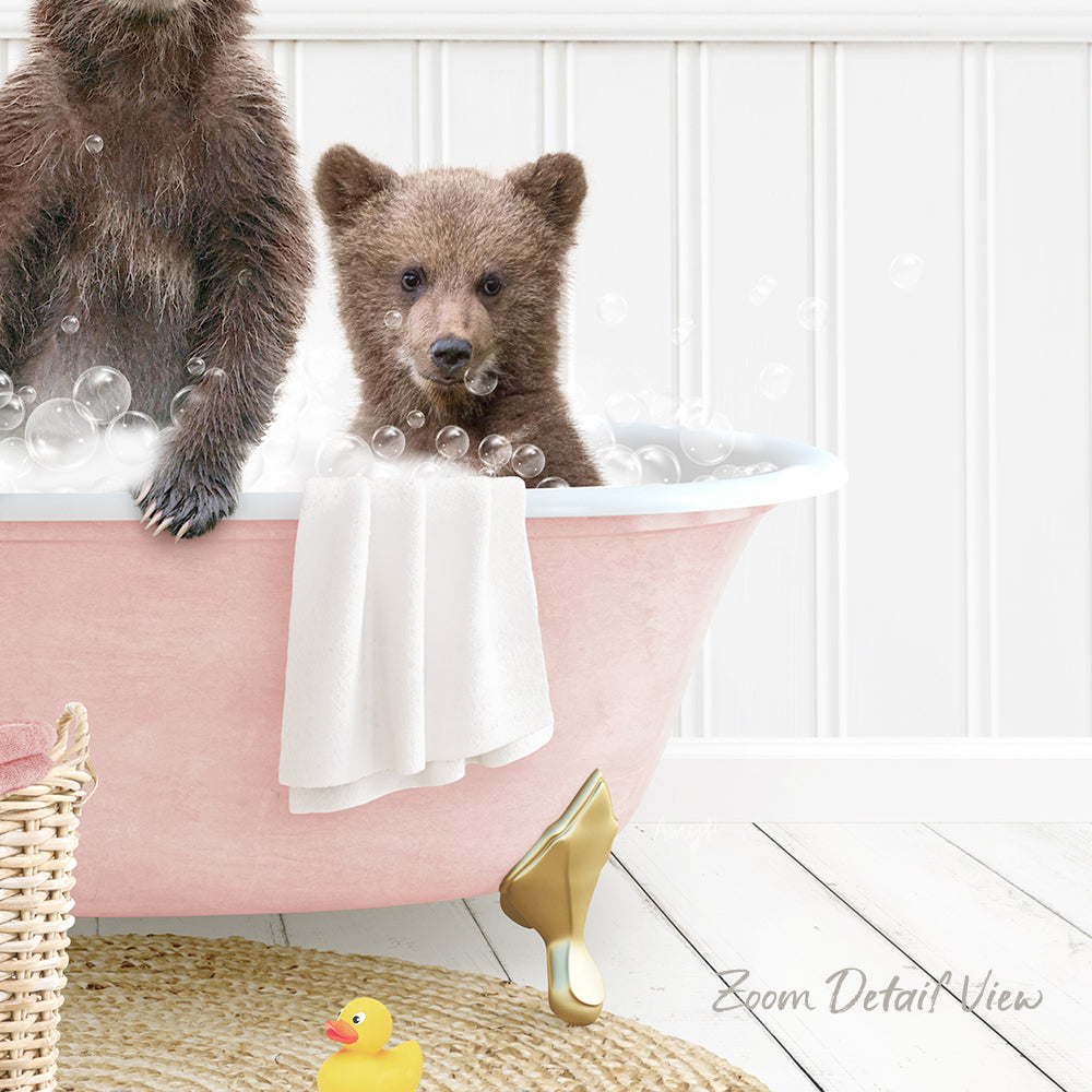 A baby bear sitting in a pink bathtub, surrounded by bubbles, with a yellow rubber duck nearby.