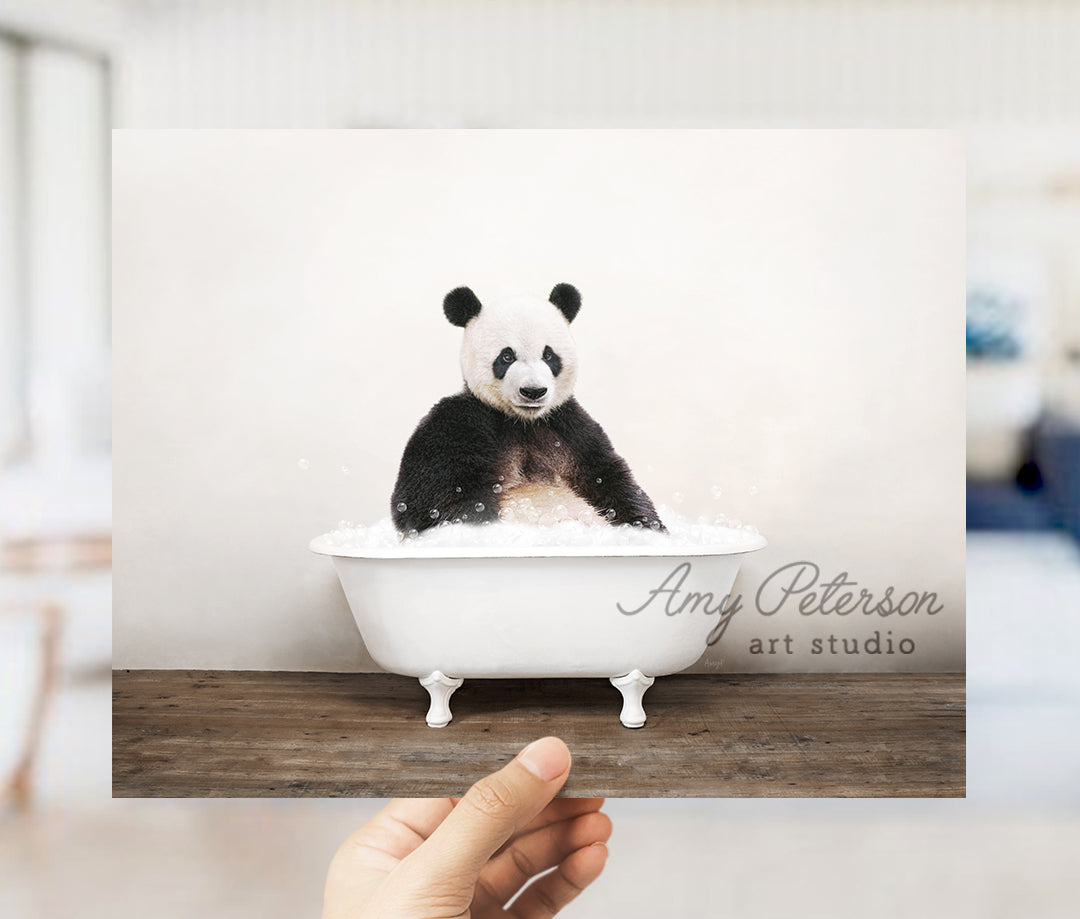 a hand holding up a card with a panda bear in a bathtub